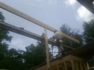 Carpenter setting a ridge beam over a new addition frame — Ice Dam Removal by Roofing Brothers in Spofford