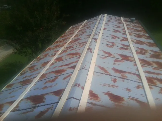 Rusted metal roof panels with new wood purlins before replacement — Storm Damage Roof Repair in Spofford by Roofing Brothers
