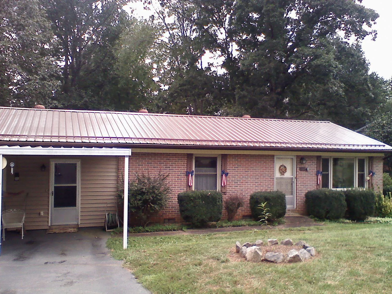 Bronze metal roof and carport on a brick ranch home — Roof Repair work by our crew in Spofford